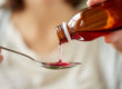 teen pouring a spoon of cough syrup for Cough Medicine Abuse