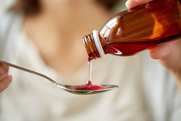 teen pouring a spoon of cough syrup for Cough Medicine Abuse