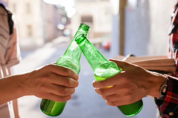 teens clinking beer bottles wondering is alcohol a drug