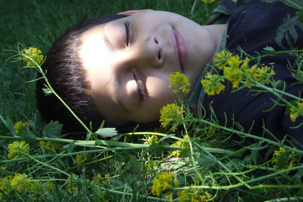 child smiling in grass after Holistic approach to treatment