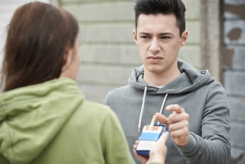 a boy takes a cigarette from a pack a girl is offering to deal with his anxiety and drug abuse