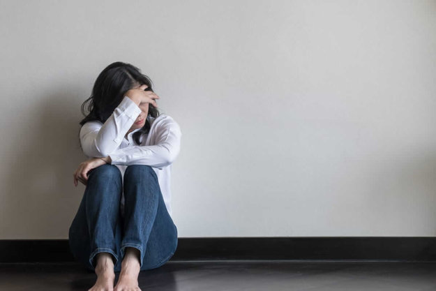 woman with her head down why it's important to know the symptoms of depression in teenagers