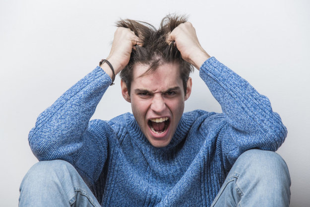 a young man pulling his hair struggling with anger management