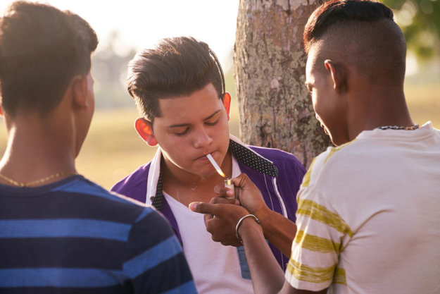 teen smoking with friends to sate nicotine addiction