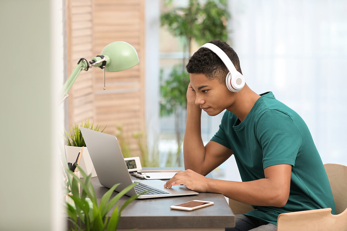 teenage boy on computer showing signs of internet addiction