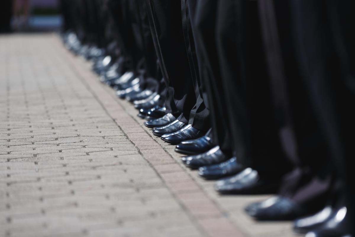 a group of people stand in a line as they consider the benefits of military school for teens