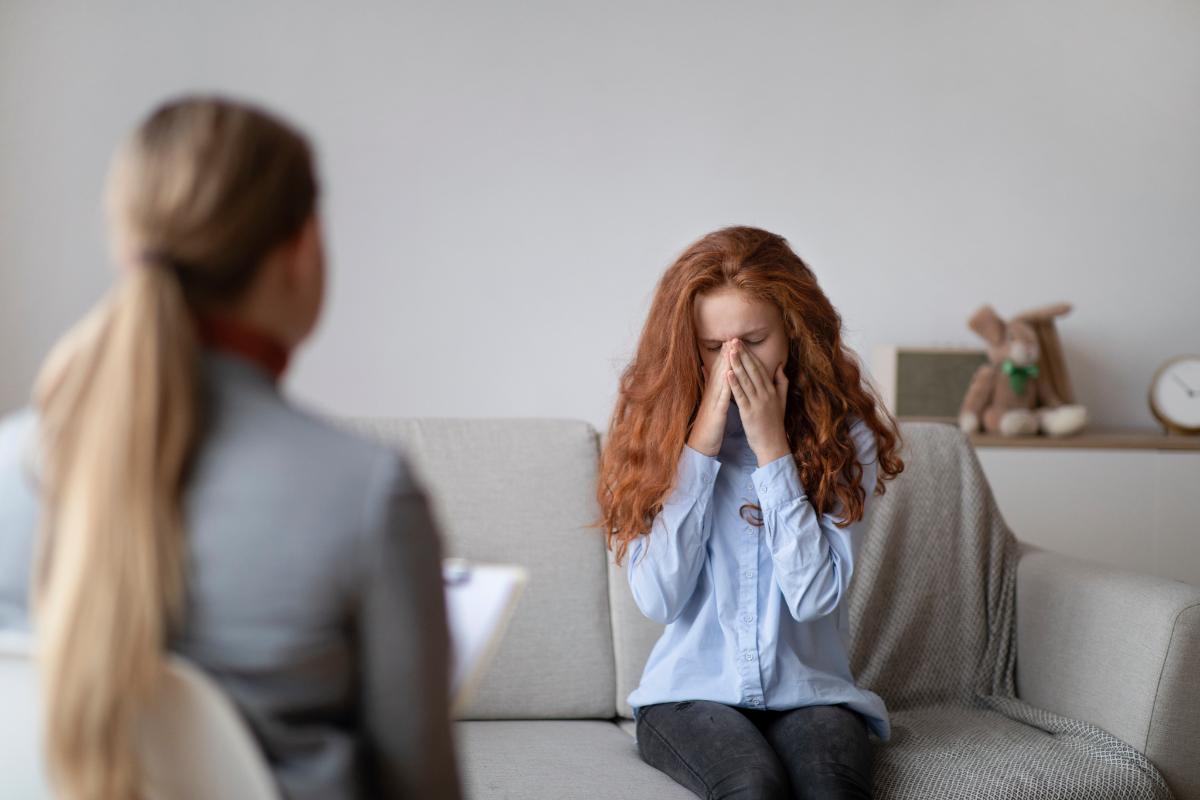 a woman discusses a substance related treatment presentation with a teen girl with red hair