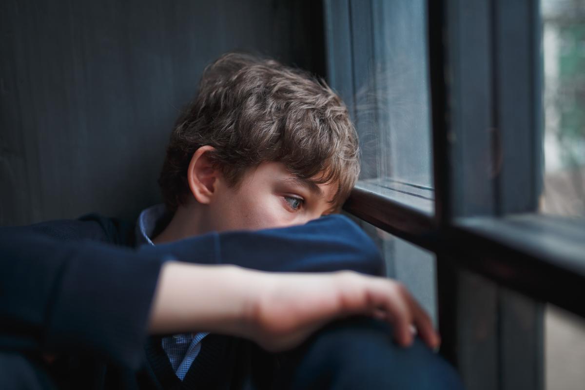 a young neurodivergent person looks out the window